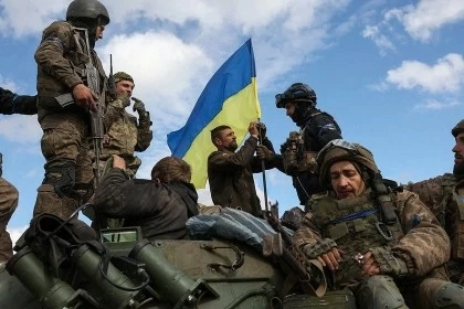 Binh sĩ Ukraine đang cắm cờ trên một chiếc xe thiết giáp chở quân (Ảnh minh họa: AFP).