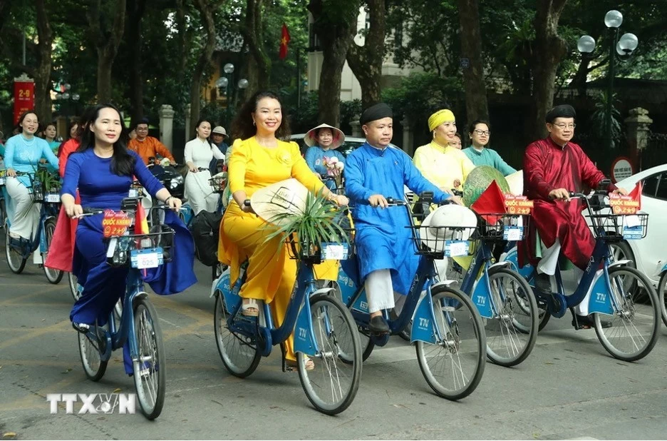 Những tà áo dài rực rỡ trên các tuyến phố Hà Nội. (Nguồn: TTXVN)