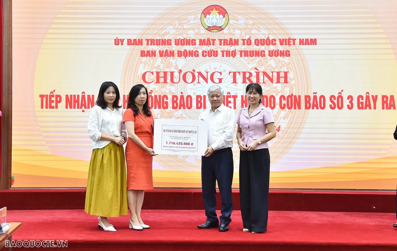 Chủ tịch Đỗ Văn Chiến tiếp nhận ủng hộ từ Đại sứ quán và Cộng đồng người Việt Nam tại Lào. (Ảnh: Anh Sơn)