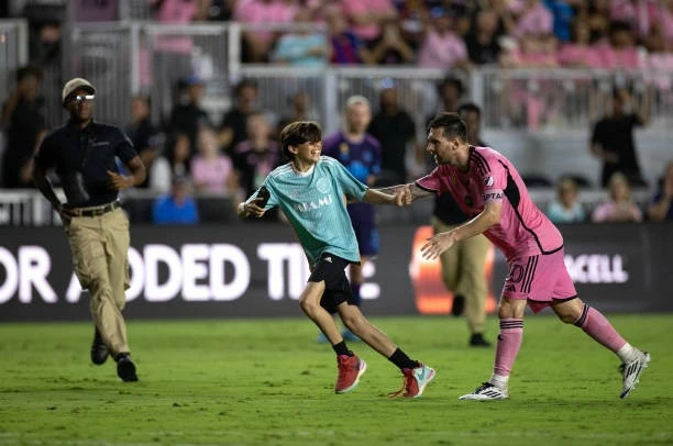 Messi bảo vệ fan nhí.