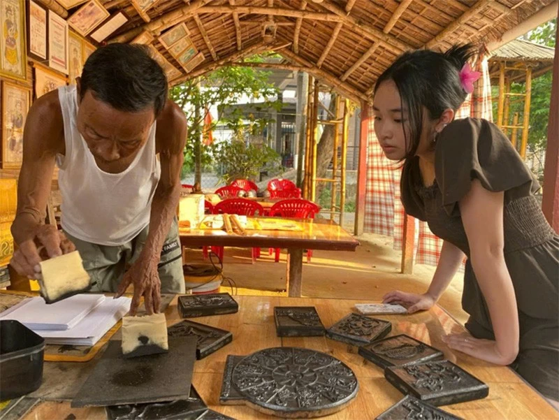 Khue Anh in a conversation with a Sình Village painting artisan in Hue.