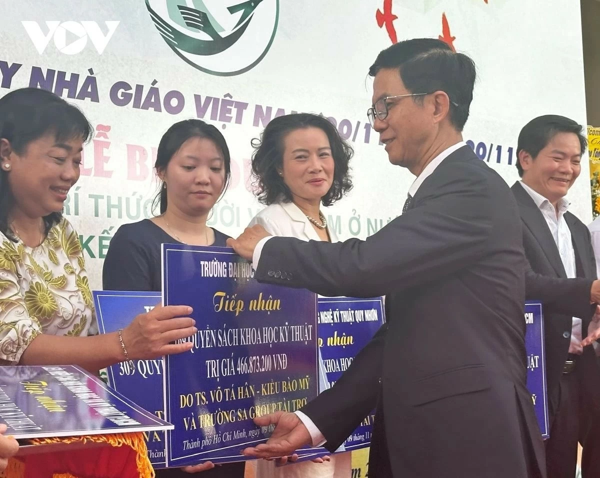 Ông Lê Văn Thu, Phó Chủ nhiệm Ủy ban về người Việt Nam ở nước ngoài TP.HCM trao biểu trưng tặng sách của TS Võ Tá Hân cho đại diện các trường. (Ảnh: Ngọc Xuân)