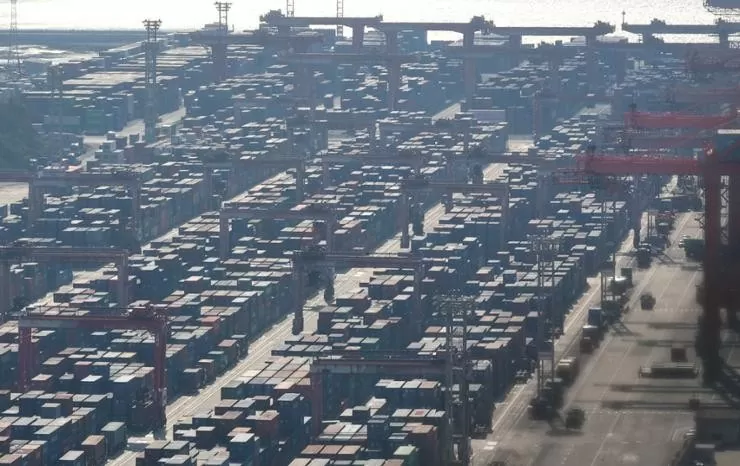 Containers laden with exports are loaded at a port in Busan, Friday. Yonhap