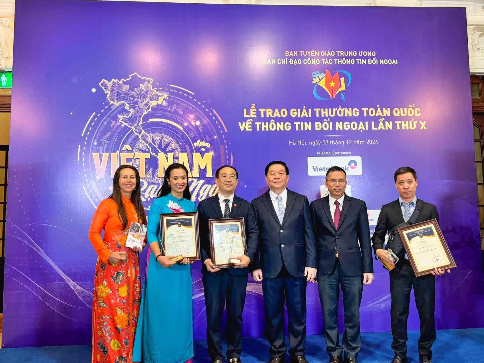 1.	Author Isabelle Muller takes a photo with Politburo member, Head of the Central Propaganda Department Nguyen Trong Nghia, and delegates at the 10th National External Information Awards ceremony.