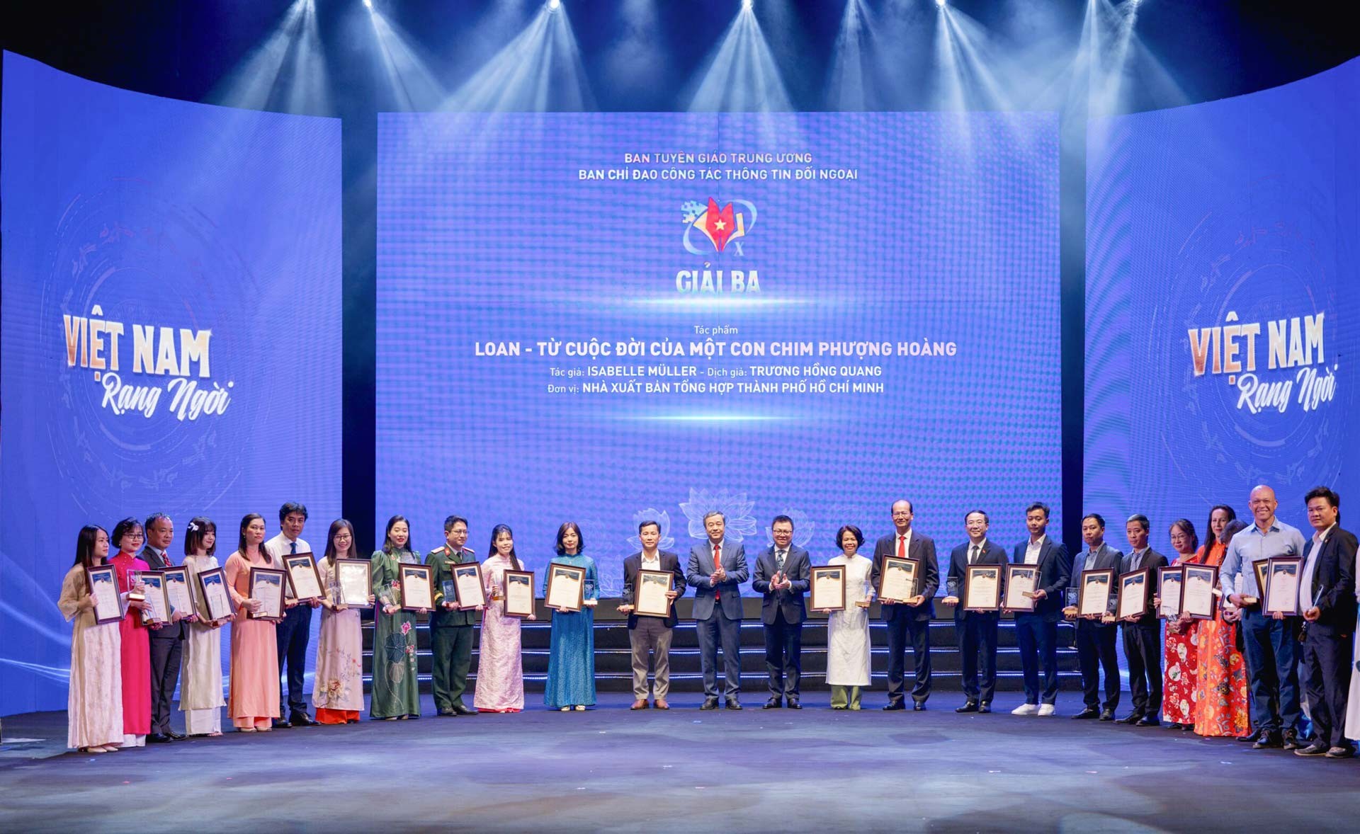 1.	Author Isabelle Muller takes a photo with authors and representatives of the team that won the Third Prize at the 10th National External Information Awards ceremony.