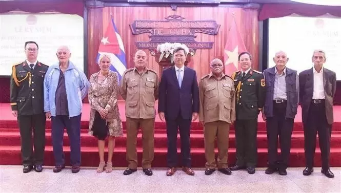 Ambassador Le Quang Long (centre) and Defence Attaché Colonel Bui Xuan Phong (third, right), take a photo with Cuban war veterans. (Photo: VNA)