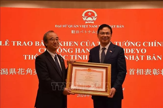 Vietnamese Ambassador to Japan Pham Quang Hieu (R) hands over Prime Minister Pham Minh Chinh's Certificate of Merit to Governor of Niigata prefecture Hanazumi Hideyo on December 20.