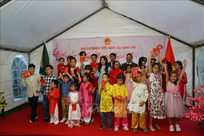 Trẻ em vui nhận lì xì mừng tuổi. Ảnh: Hồng Minh - Pv TTXVN tại Nam Phi Trẻ em vui nhận lì xì mừng tuổi. Ảnh: Hồng Minh - Pv TTXVN tại Nam Phi