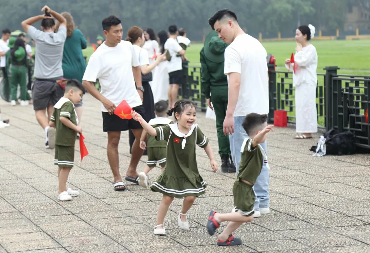 Nhiều em nhỏ được gia đình dẫn tới Quảng trường Ba Đình lịch sử chụp ảnh cùng cờ đỏ sao vàng. (Ảnh: Thành Long)