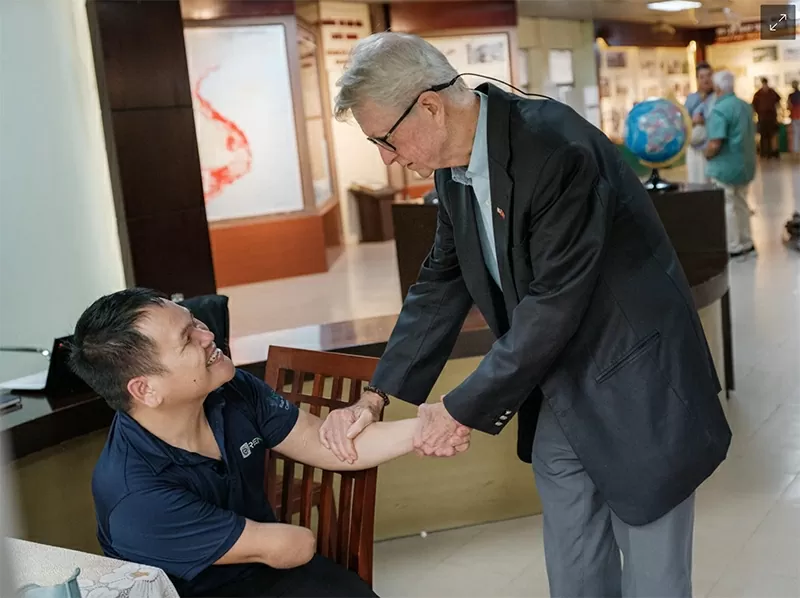 Cựu chiến binh chiến tranh Việt Nam Chuck Searcy với một người đàn ông bị thương do bom chùm Ảnh: Linh Phạm / DER SPIEGEL
