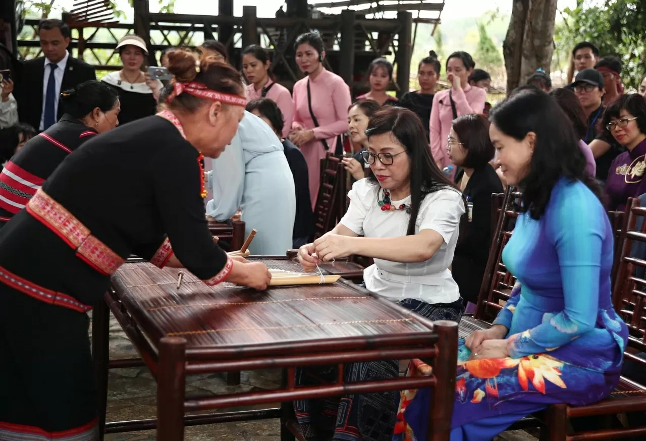 Phu nhân Lê Thị Bích Trân trải nghiệm làm đàn T'rưng đặc trưng của núi rừng Tây Nguyên.