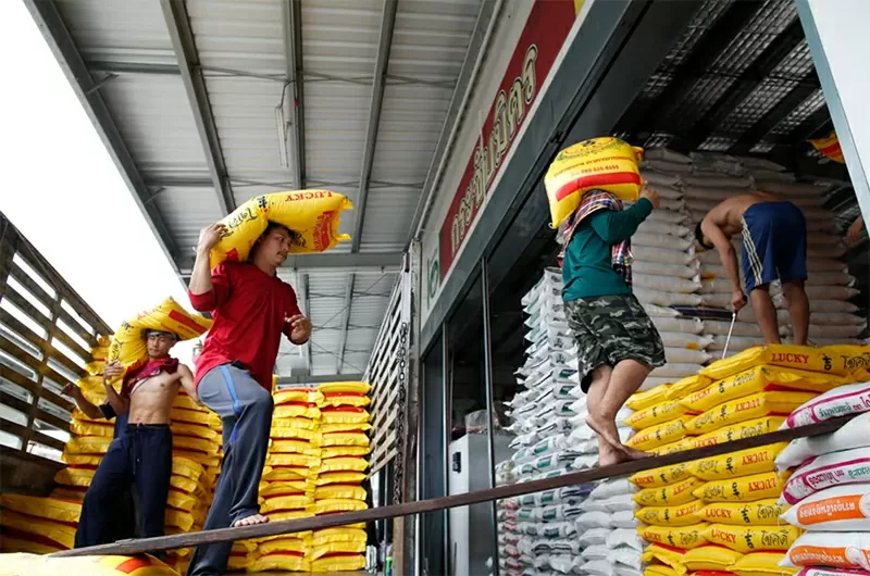 Công nhân mang bao gạo để dỡ hàng tại một chợ gạo bán buôn ở ngoại ô Bangkok, Thái Lan. ASEAN có thể chuyển hướng các chính sách để giúp thúc đẩy sự đa dạng sản xuất trong khu vực. Ảnh: EPA-EFE