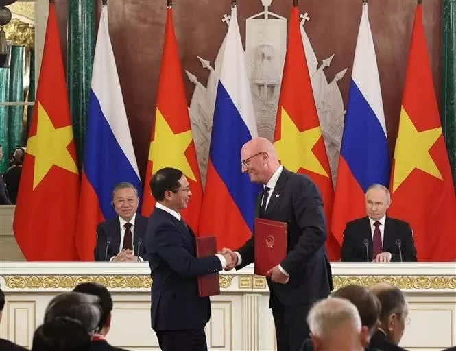 Vietnamese Deputy Prime Minister and Minister of Foreign Affairs Bui Thanh Son (L) and Russian Deputy Prime Minister Dmitry Chernyshenko exchange the agreement on cooperation.