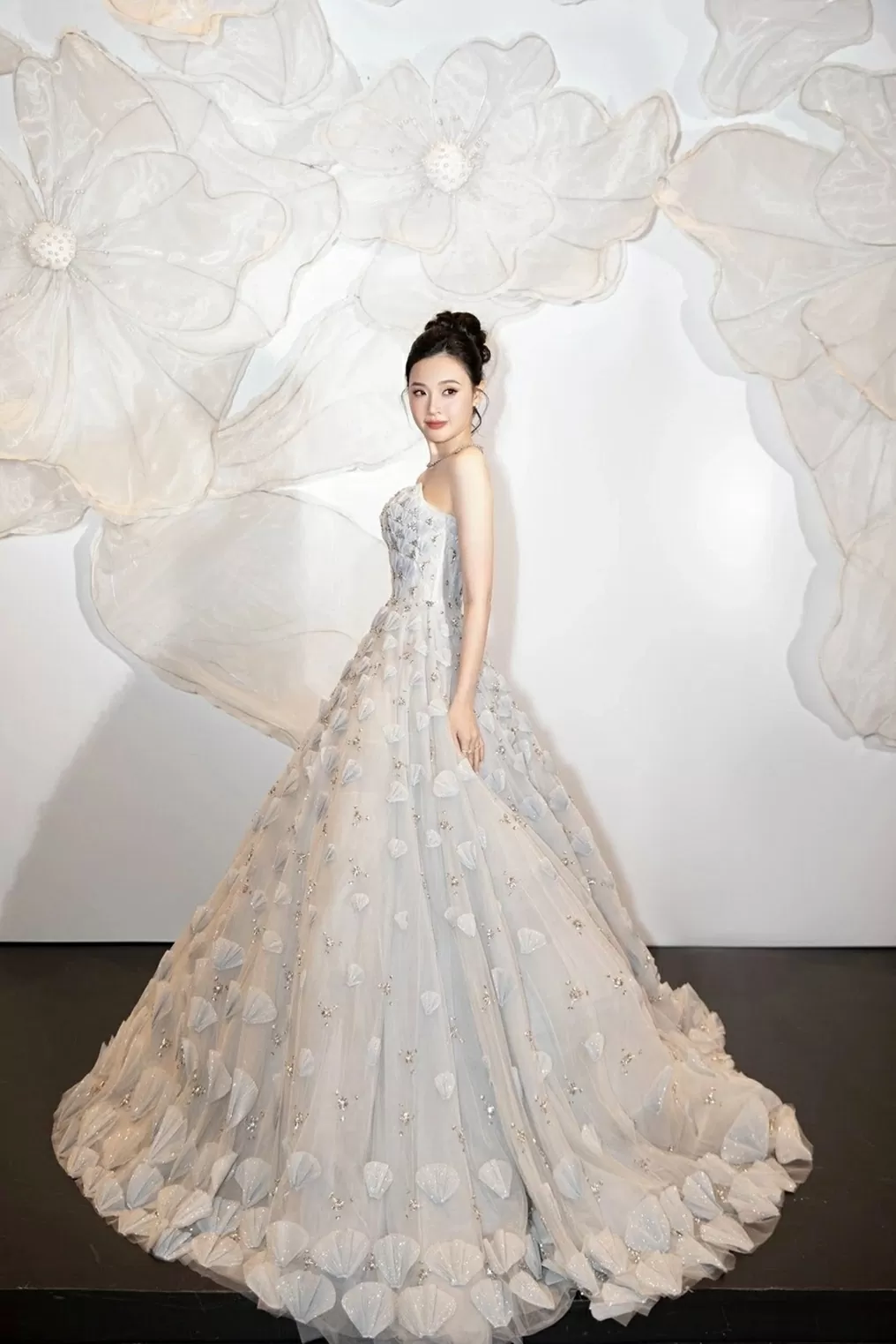 Gần đây, xuất hiện trên thảm đỏ show thời trang Veil of the Desert, Midu hóa công chúa cùng chiếc váy xòe bồng tốn cả trăm mét vải. Thiết kế được tô điểm bằng những hạt pha lê lấp lánh cùng các cánh hoa đan xen đính kết thủ công, giúp Midu trông như bước ra từ cổ tích.