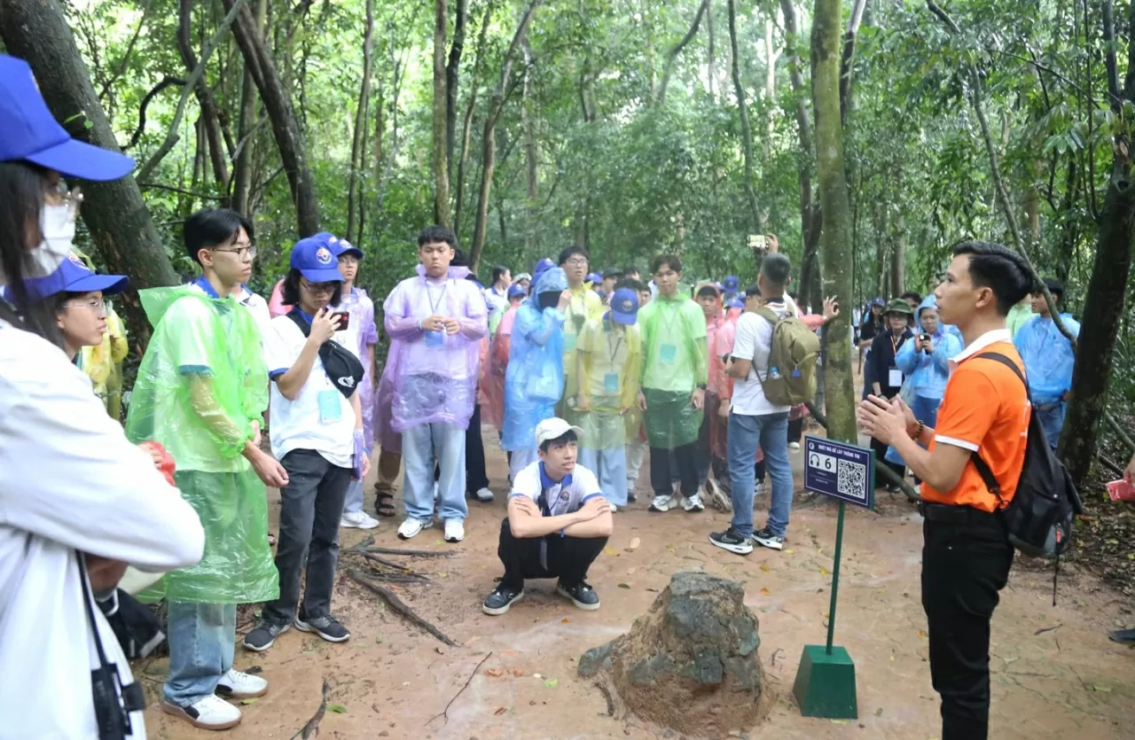 Dù thời tiết có mưa nặng hạt nhưng các thanh niên, sinh viên kiều bào vẫn rất hào hứng khi lần đầu tới với di tích Địa đạo Củ Chi. (Ảnh: Thành Long)