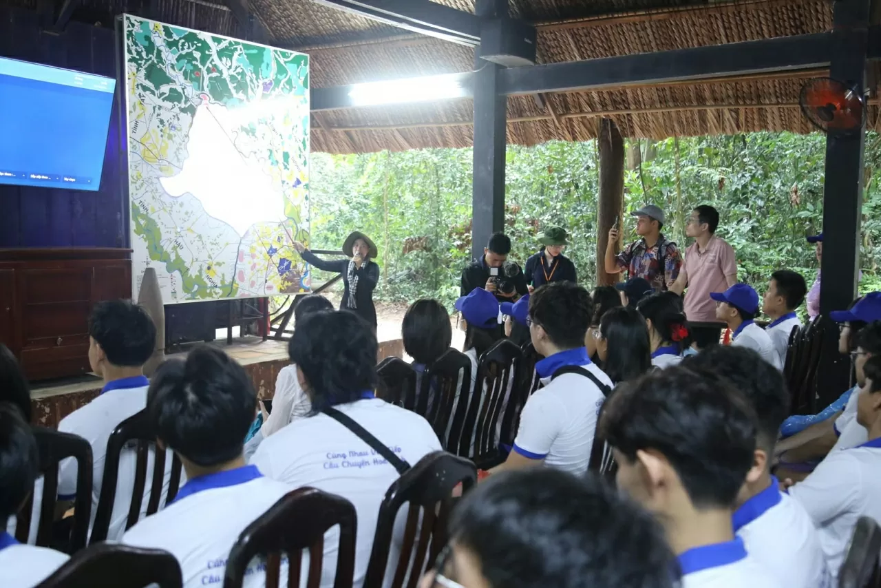 Các kiều bào trẻ chăm chú lắng nghe hướng dẫn viên giới thiệu về địa danh lịch sử Địa đạo Củ Chi. (Ảnh: Thành Long)