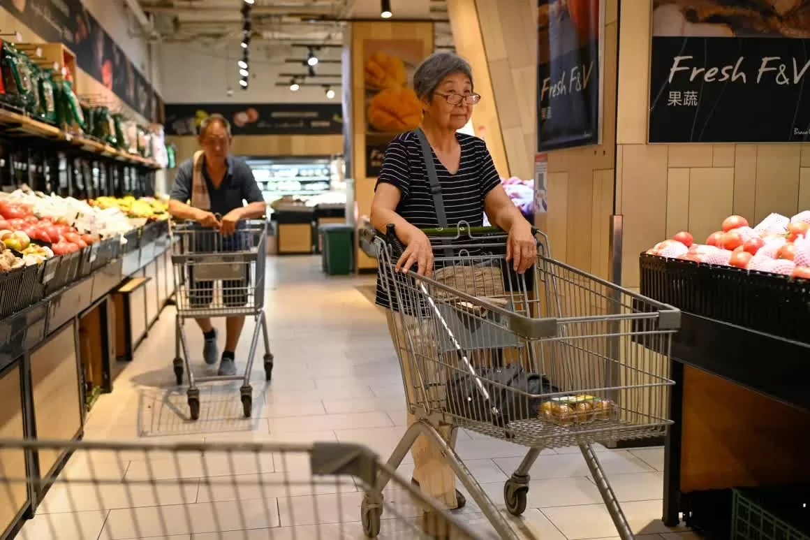 Khách hàng đẩy xe đẩy hàng tại một siêu thị ở Bắc Kinh. (Nguồn: Getty)