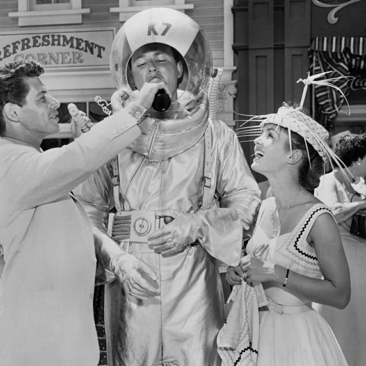 Một khoảnh khắc vui nhộn trong ngày khai trương Disneyland: nam ca sĩ Eddie Fisher (trái) mời nước cho Don MacDonald, trong khi nữ diễn viên Debbie Reynolds đứng cạnh cười tươi. (Nguồn: Getty)