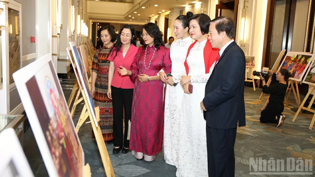 Các đại biểu xem tranh ảnh trưng bày tại chương trình. (Ảnh: KHÁNH LAN)