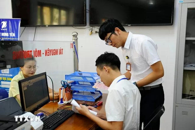 Cán bộ, công chức Trung tâm phục vụ hành chính công xã Yên Mỹ (Hưng Yên) giải quyết thủ tục hành chính liên quan đến đất đai cho người dân. (Ảnh: Mạnh Khánh/TTXVN)