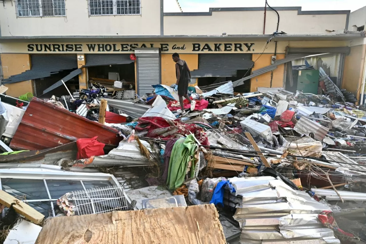 Một nam thanh niên đi bộ trên đống đổ nát còn lại trên đường phố sau khi bão Melissa quét qua thị trấn Black River. Số người thiệt mạng đã tăng lên 49 khi cơn bão tiếp tục tàn phá khu vực Caribe, trong khi các công nhân tại Jamaica đang nỗ lực dọn dẹp đường sá và tiếp cận người dân ở những khu vực bị cô lập và chia cắt. (Nguồn: The Guardian)