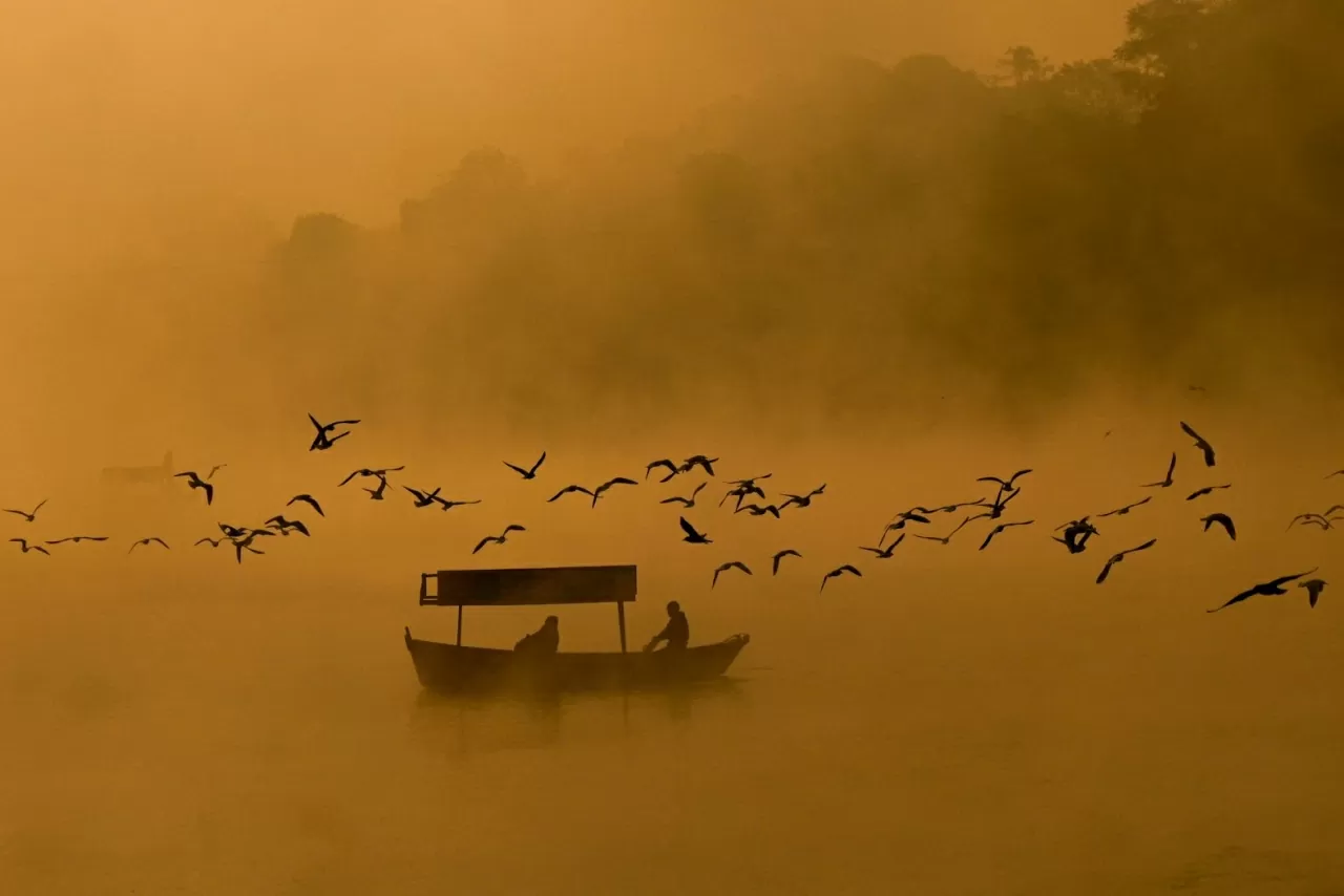 Những người đàn ông chèo thuyền trên dòng sông Narmada mờ sương ở Jabalpur, Ấn Độ, vào thứ Ba, ngày 11 tháng 11. (Nguồn: CNN)