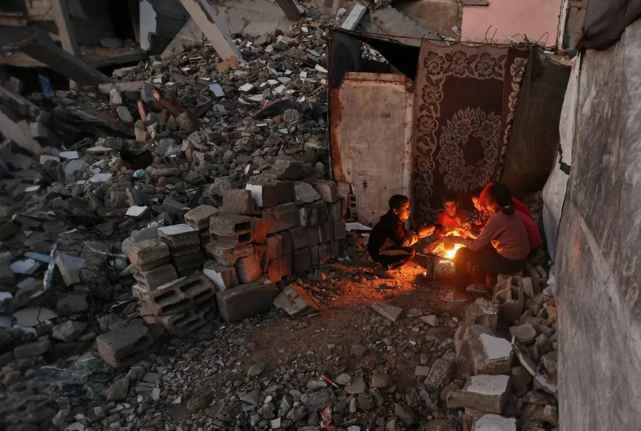 Những đứa trẻ Palestine sưởi ấm đôi tay bên ngọn lửa vào một ngày mưa tại Khan Younis. Tổ chức Ân xá Quốc tế (Amnesty International) cho biết Israel vẫn đang “tiếp tục thực hiện hành vi diệt chủng” đối với người Palestine ở Dải Gaza, bất chấp thỏa thuận ngừng bắn đã đạt được vào tháng trước. (Nguồn The Guardian)