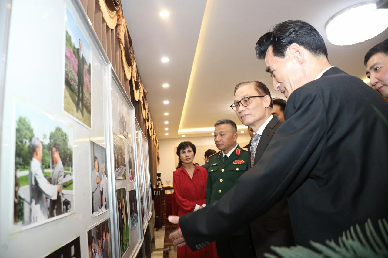 Ủy viên Bộ Chính trị, Bí thư Đảng ủy, Bộ trưởng Ngoại giao Lê Hoài Trung cùng các đại biểu tham quan triển lãm ảnh thành tựu của Đảng và Nhân dân Triều Tiên . (Ảnh: Thành Long)
