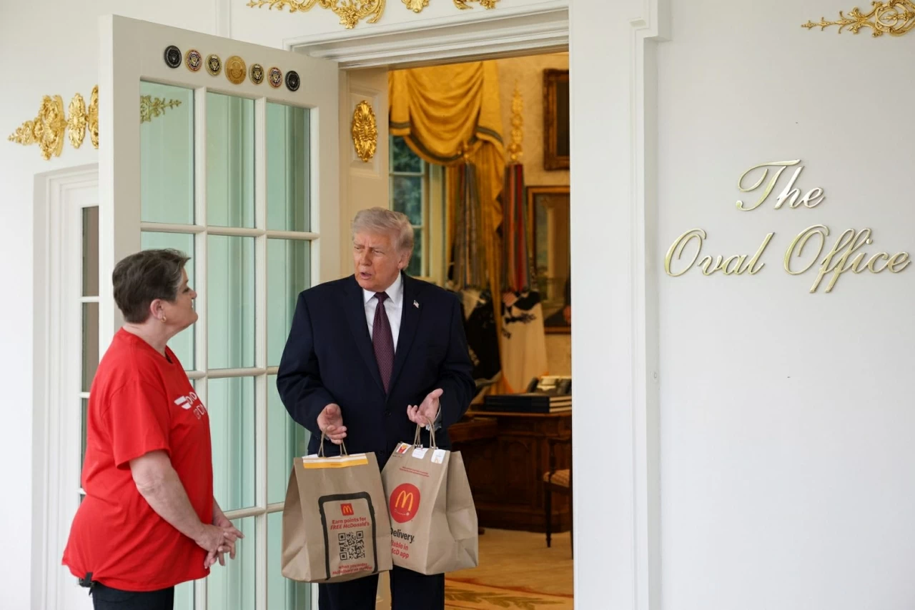 Tổng thống Mỹ Donald Trump nhận một đơn giao hàng từ Sharon Simmons của DoorDash bên ngoài Phòng Bầu dục tại Nhà Trắng vào thứ Hai, ngày 13 tháng 4. Đơn hàng McDonald's này là một phần của hoạt động dàn dựng nhằm chụp ảnh quảng bá cho chính sách “không đánh thuế tiền tip” của ông Trump trước ngày khai thuế. (Nguồn: Getty Images) Tổng thống Mỹ Donald Trump nhận một đơn giao hàng từ Sharon Simmons của DoorDash bên ngoài Phòng Bầu dục tại Nhà Trắng vào thứ Hai, ngày 13 tháng 4. Đơn hàng McDonald's này là một phần của hoạt động dàn dựng nhằm chụp ảnh quảng bá cho chính sách “không đánh thuế tiền tip” của ông Trump trước ngày khai thuế. (Nguồn: Getty Images)