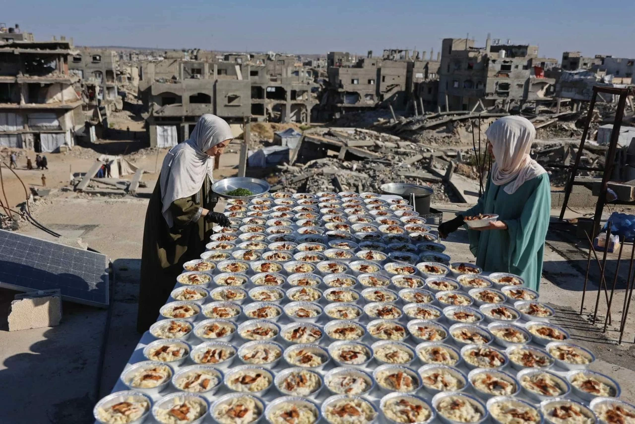Hai chị em người Palestine Lina và Aya Zeid chuẩn bị các suất ăn trên mái nhà để phân phát cho trẻ em phải sơ tán ở phía bắc Dải Gaza. (Nguồn: Getty Images) Hai chị em người Palestine Lina và Aya Zeid chuẩn bị các suất ăn trên mái nhà để phân phát cho trẻ em phải sơ tán ở phía bắc Dải Gaza. (Nguồn: Getty Images)