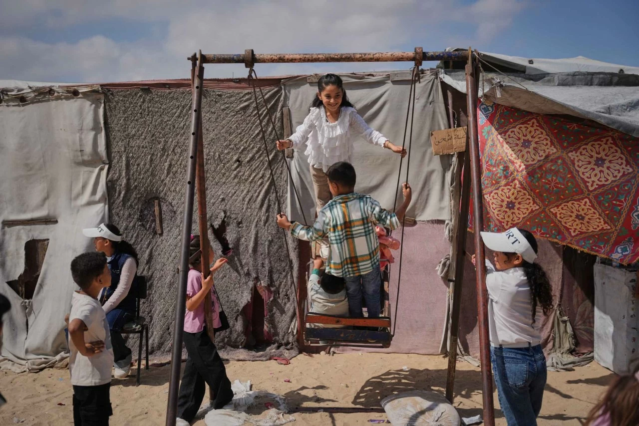 Những trẻ em Palestine phải di dời khỏi nhà cửa vui chơi trên chiếc xích đu tại một khu lều tạm ở Gaza trong dịp Eid al-Adha. (Nguồn: X)