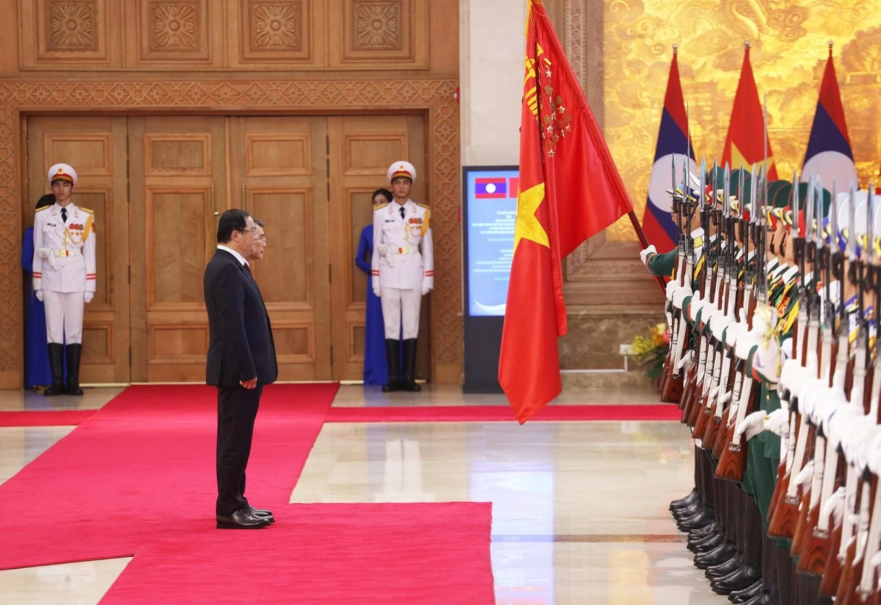 Thủ tướng Chính phủ Lê Minh Hưng và Thủ tướng Lào Sonexay Siphandone cúi chào Quân kỳ Quyết thắng. (Ảnh: Thành Long) Thủ tướng Chính phủ Lê Minh Hưng và Thủ tướng Lào Sonexay Siphandone cúi chào Quân kỳ Quyết thắng. (Ảnh: Thành Long)