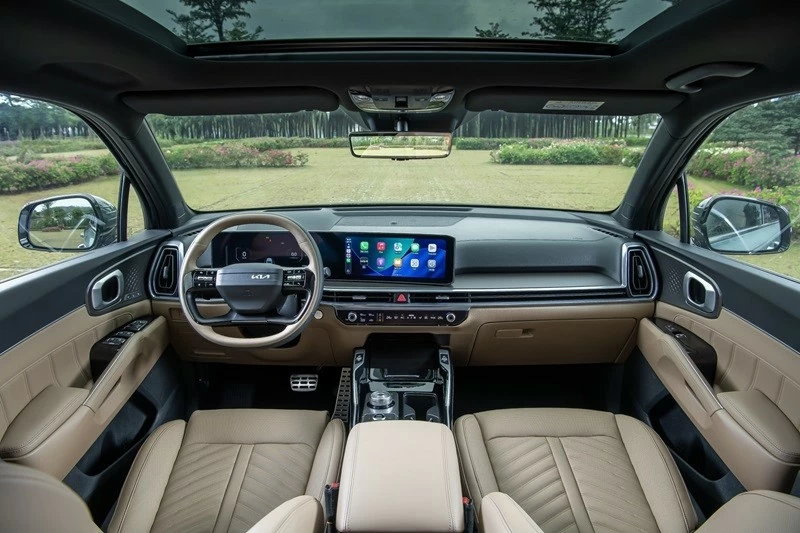 Khoang lái của Kia Sorento Hybrid 2026 được làm mới với vô-lăng hai chấu đáy phẳng cùng cụm màn hình cong đặt nổi trên táp-lô. 