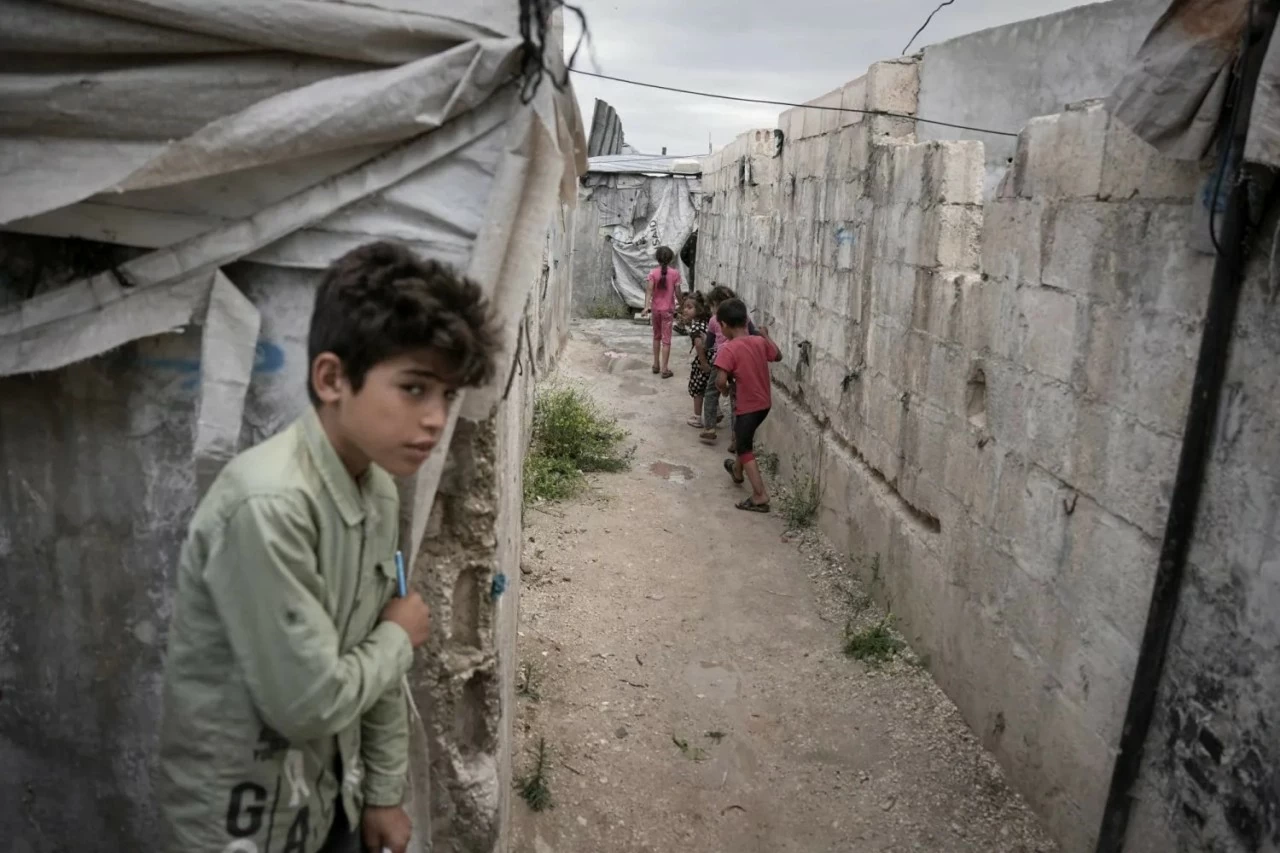 Trẻ em vui chơi tại trại Al-Karama gần làng Atmeh, tỉnh Idlib, Syria, ngày 19/5/2026. Khu trại được dựng lên từ những năm đầu của cuộc xung đột Syria để làm nơi ở cho người dân phải di dời trong nước. (Ảnh: Asharq Al-Awsat) Trẻ em vui chơi tại trại Al-Karama gần làng Atmeh, tỉnh Idlib, Syria, ngày 19/5/2026. Khu trại được dựng lên từ những năm đầu của cuộc xung đột Syria để làm nơi ở cho người dân phải di dời trong nước. (Ảnh: Asharq Al-Awsat)