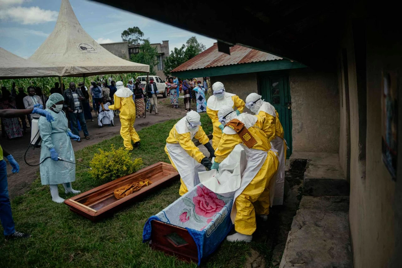 Các thành viên của đội Chữ thập đỏ Congo khiêng thi thể một phụ nữ nghi tử vong do Ebola, đặt vào quan tài trước khi tiến hành an táng an toàn tại nhà riêng của bà trong thành phố. Theo một phân tích của các quan chức y tế Mỹ, đợt bùng phát Ebola tại khu vực Trung Phi hiện nay có nguy cơ lan rộng với quy mô tương đương đợt dịch tồi tệ nhất trong lịch sử ở Tây Phi giai đoạn 2014–2016, vốn đã cướp đi sinh mạng của hơn 11.000 người. (Nguồn: Getty Images) Các thành viên của đội Chữ thập đỏ Congo khiêng thi thể một phụ nữ nghi tử vong do Ebola, đặt vào quan tài trước khi tiến hành an táng an toàn tại nhà riêng của bà trong thành phố. Theo một phân tích của các quan chức y tế Mỹ, đợt bùng phát Ebola tại khu vực Trung Phi hiện nay có nguy cơ lan rộng với quy mô tương đương đợt dịch tồi tệ nhất trong lịch sử ở Tây Phi giai đoạn 2014–2016, vốn đã cướp đi sinh mạng của hơn 11.000 người. (Nguồn: Getty Images)