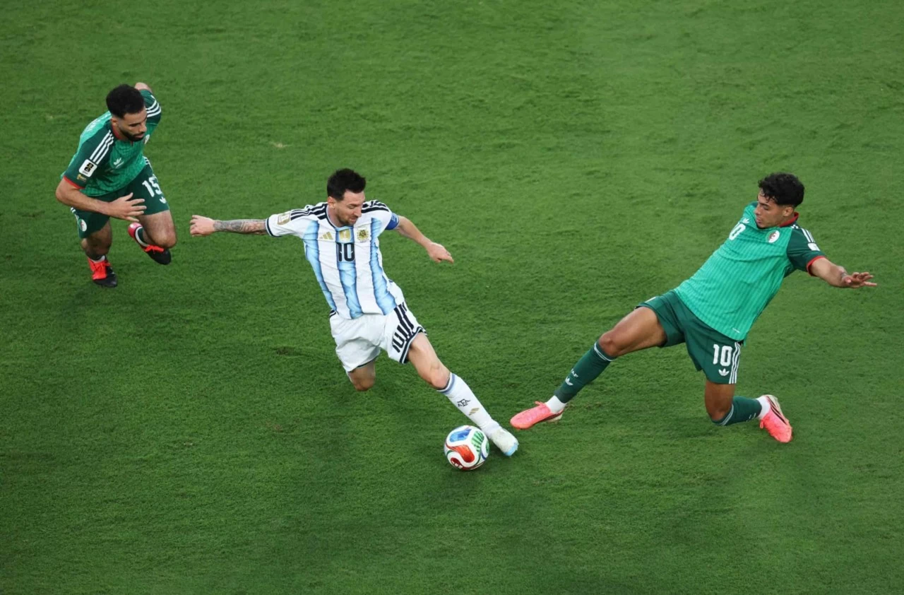 Siêu sao Lionel Messi của Argentina đi bóng vượt qua hai cầu thủ Algeria trong trận ra quân của đội nhà tại World Cup ở Kansas City, bang Missouri (Mỹ), ngày 16/6. Messi lập hat-trick, giúp nhà đương kim vô địch Argentina giành chiến thắng 3-0. Với ba bàn thắng này, anh cân bằng kỷ lục 16 bàn thắng tại các kỳ World Cup của Miroslav Klose – thành tích ghi bàn cao nhất trong lịch sử giải đấu. (Nguồn: Getty Images)