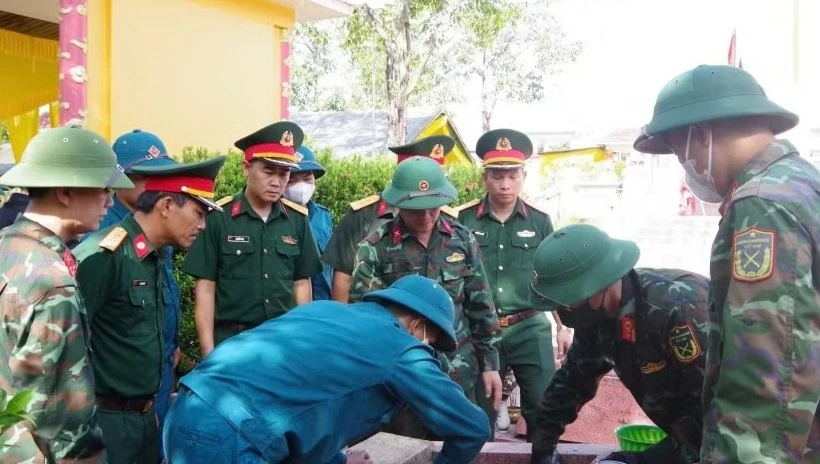 Lực lượng chuyên trách tiến hành khai quật mộ liệt sỹ. (Nguồn: TTXVN)