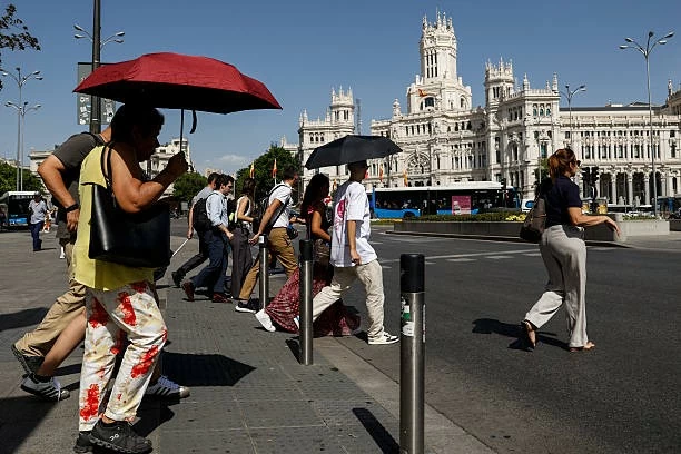 Người dân dùng ô che nắng tại quảng trường Cibeles ở Madrid, Tây Ban Nha, ngày 23/6, khi nhiều thành phố châu Âu ghi nhận nhiệt độ tiến sát 40 độ C. (Nguồn: Getty Images)