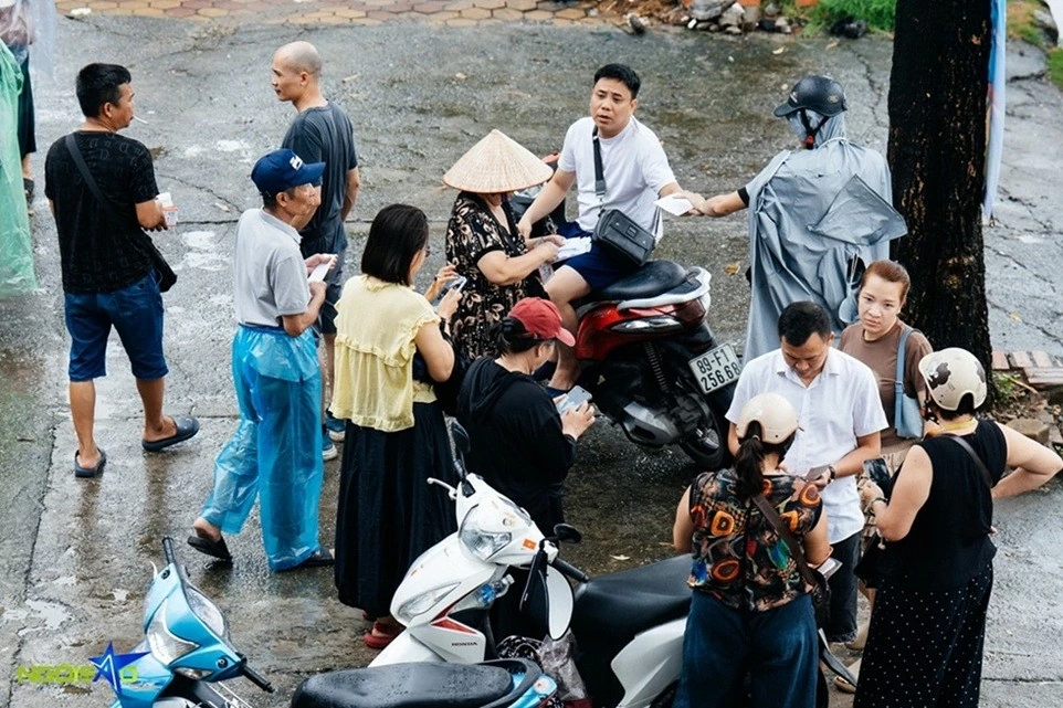 Người hâm mộ xếp hàng dưới trời mưa to để mua vé xem trận tuyển Việt Nam và Singapore