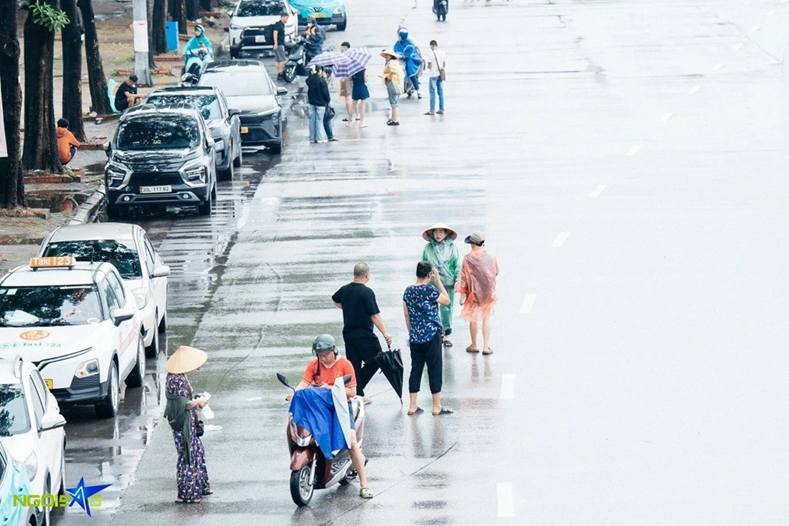 Người hâm mộ xếp hàng dưới trời mưa to để mua vé xem trận tuyển Việt Nam và Singapore