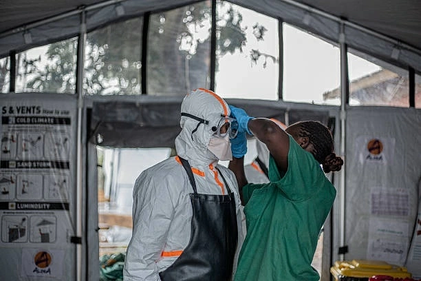 Nhân viên y tế mặc đồ bảo hộ trước khi vào Trung tâm Điều trị Ebola Rwampara ở Bunia, tỉnh Ituri, Cộng hòa Dân chủ Congo, ngày 13/7. (Nguồn: Getty Images) Nhân viên y tế mặc đồ bảo hộ trước khi vào Trung tâm Điều trị Ebola Rwampara ở Bunia, tỉnh Ituri, Cộng hòa Dân chủ Congo, ngày 13/7. (Nguồn: Getty Images)