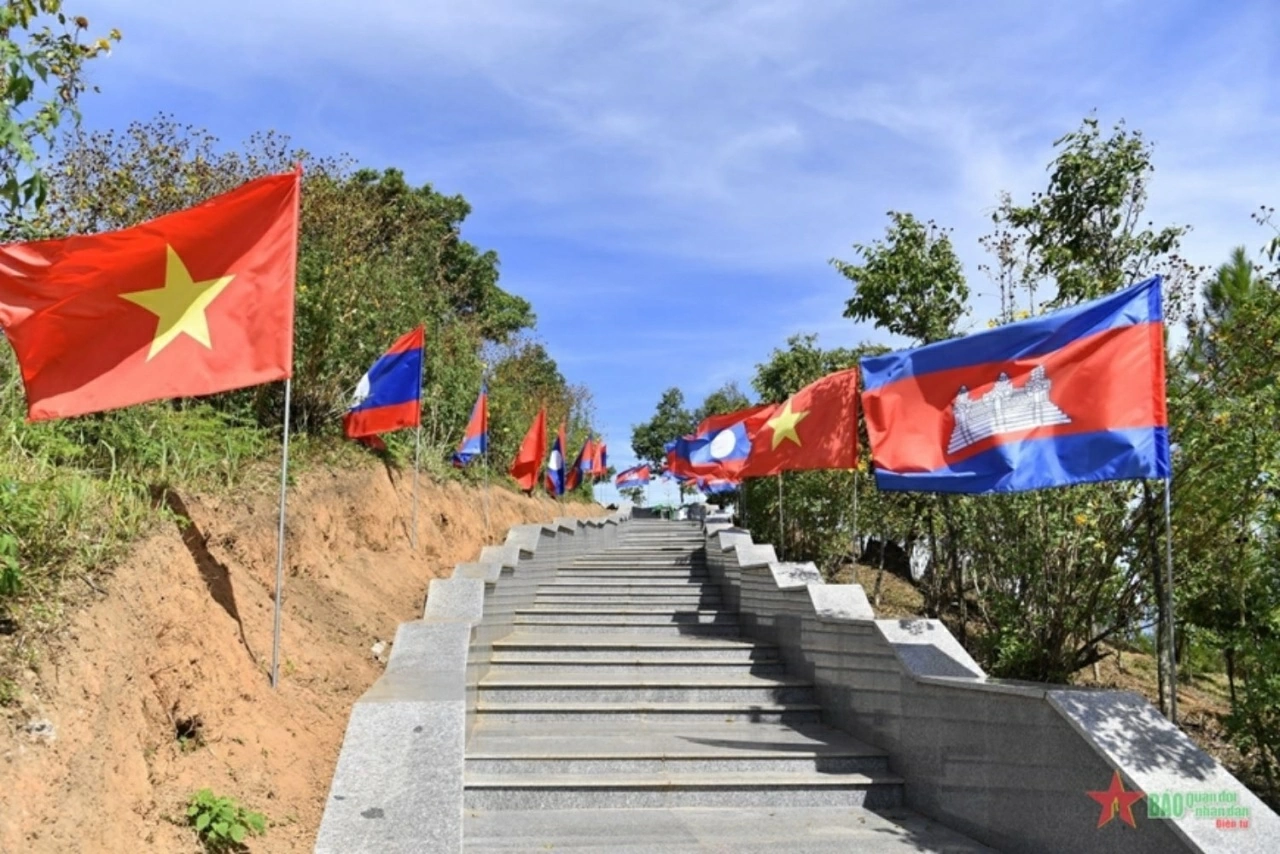 Quốc kỳ ba nước Việt Nam-Lào-Campuchia tung bay dọc lối lên cột mốc ba biên - khu vực vẫn được ví von với “tiếng gà gáy sáng ba nước cùng nghe”. (Nguồn: QĐND)