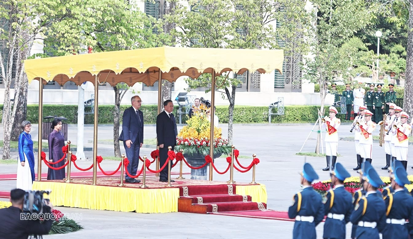 Trong tiếng nhạc chào mừng, hai lãnh đạo đi dọc thảm đỏ, bước lên bục danh dự. Quân nhạc cử Quốc thiều hai nước. (Ảnh: Thành Long)