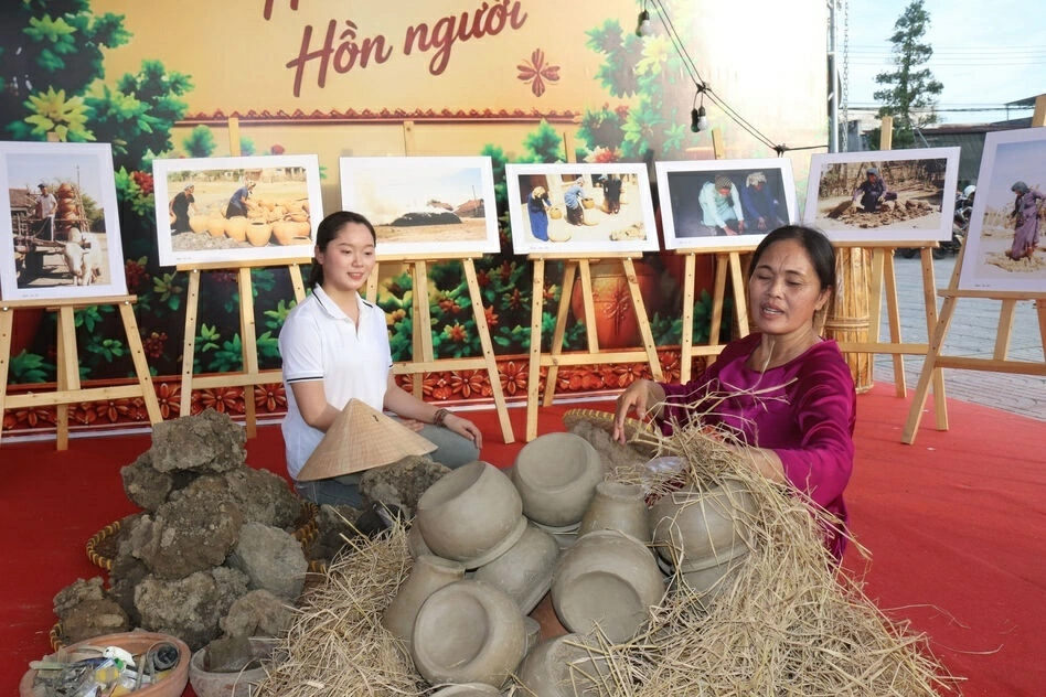 Du khách trải nghiệm làm gốm cùng nghệ nhân. (Ảnh: X.H)