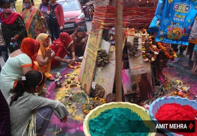 Những người phụ nữ trang trí giàn thiêu Holika. Những ngày trước khi diễn ra lễ hội, người dân bắt đầu thu thập gỗ và các vật liệu dễ cháy cho lửa trại tại công viên, trung tâm cộng đồng, khu vực gần ngôi đền và các không gian mở khác. 