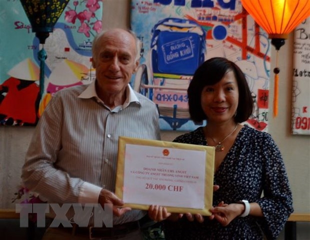Đại sứ Lê Linh Lan tiếp nhận đóng góp 20.000 CHF cho Quỹ vaccine của doanh nhân Thụy Sĩ Urs Angst. (Ảnh: Tố Uyên/TTXVN)