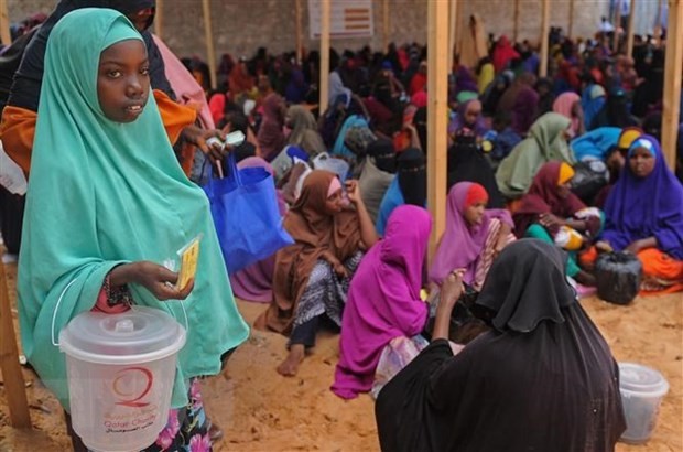 Người dân xếp hàng chờ được phát lương thực cứu trợ tại trại tị nạn ở Mogadishu, Somalia. (Ảnh: AFP/TTXVN)