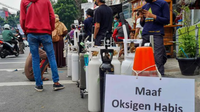 Biển báo có nội dung 'xin lỗi, hết ôxy' được nhìn thấy khi mọi người xếp hàng bên ngoài một cửa hàng nạp ôxy để đổ đầy bình cho các thành viên trong gia đình bị bệnh ở Jakarta. Hình: AFP Nguồn: AFP
