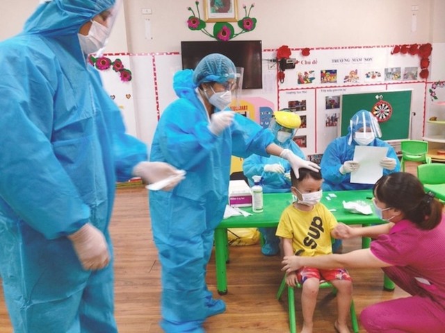 Nhân viên y tế lấy mẫu xét nghiệm cho học sinh trường Mầm non Sao Mai, TP Bắc Ninh.