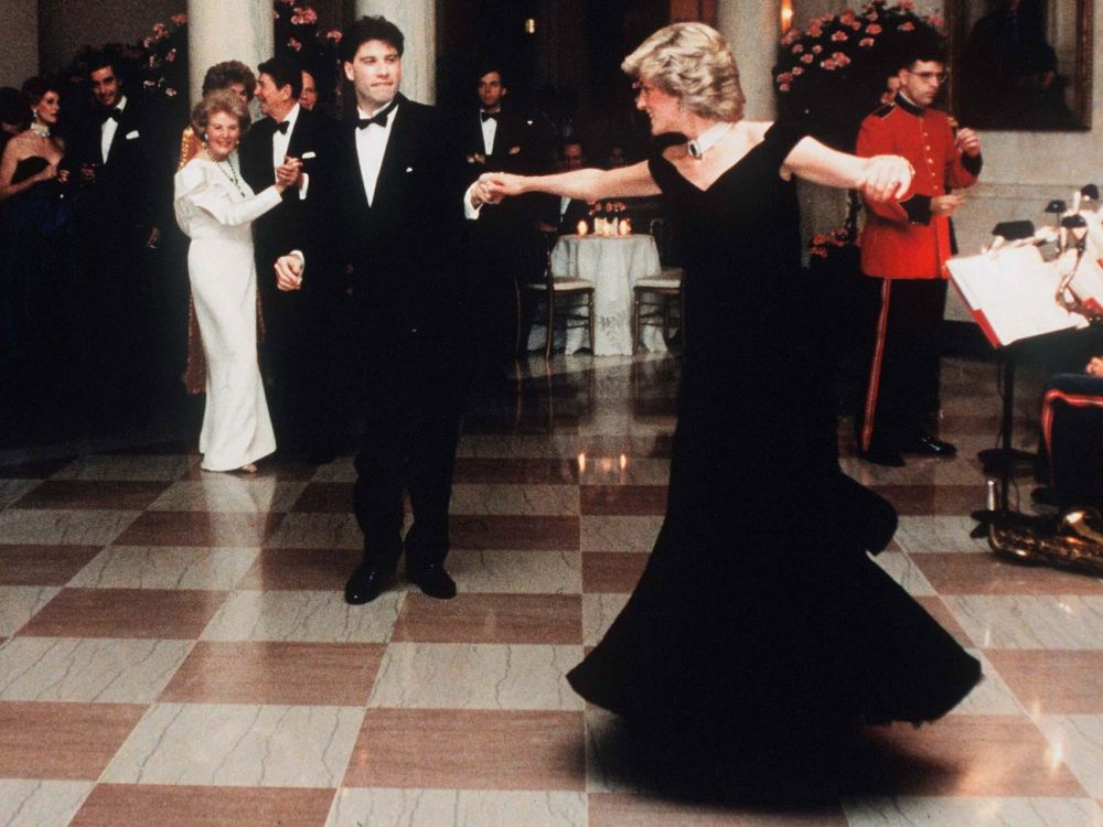 Năm 1985, Công nương Diana mặc chiếc váy nhung sẫm màu này và kết hợp nó với chiếc vòng ngọc trai nổi tiếng của mình.  Tại đây, cô ấy đang khiêu vũ với nam diễn viên John Travolta tại Nhà Trắng ở Washington DC. (Nguồn: Getty Iamges)